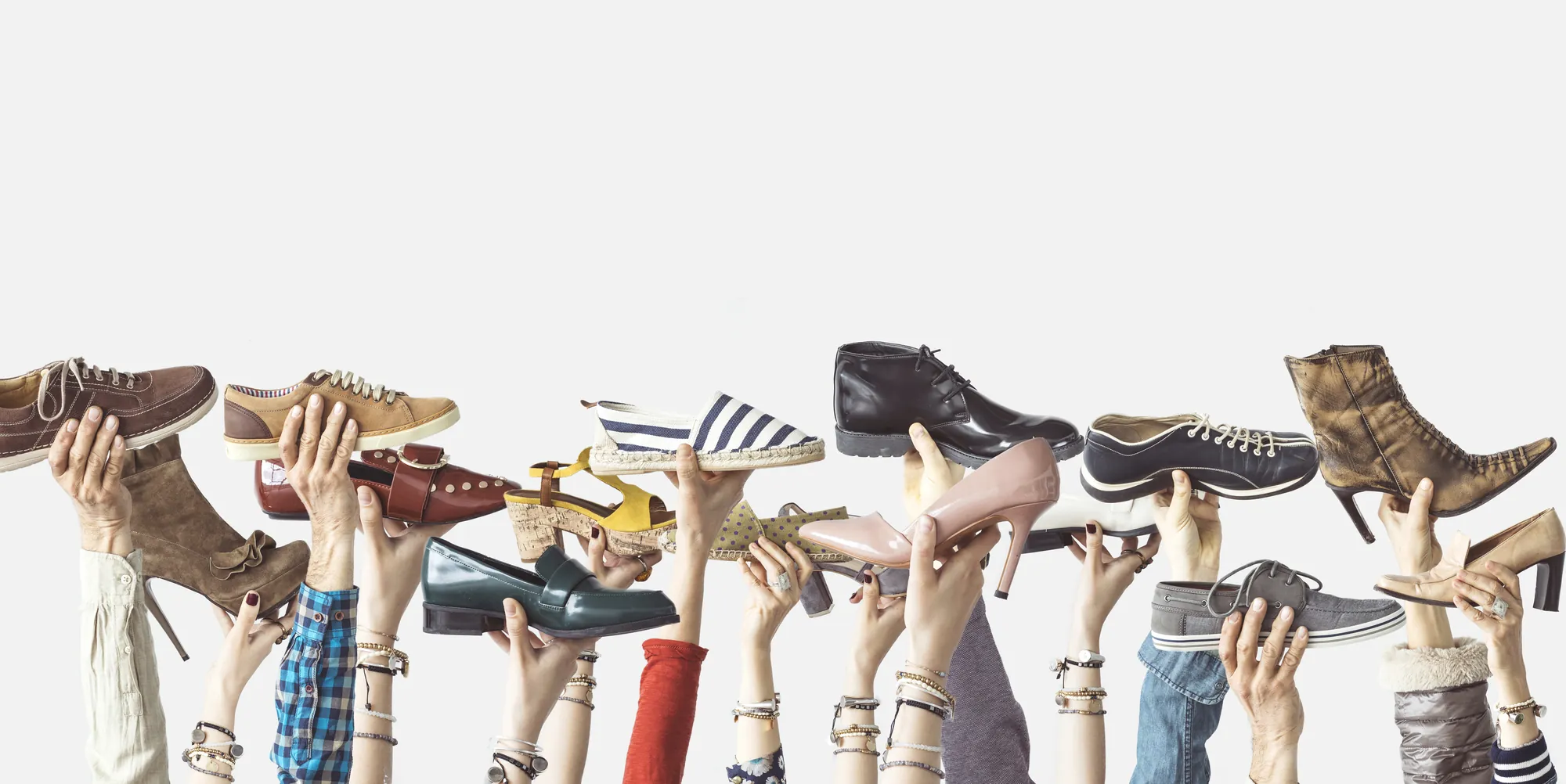 Viele Hände halten unterschiedliche Damenschuhe hoch