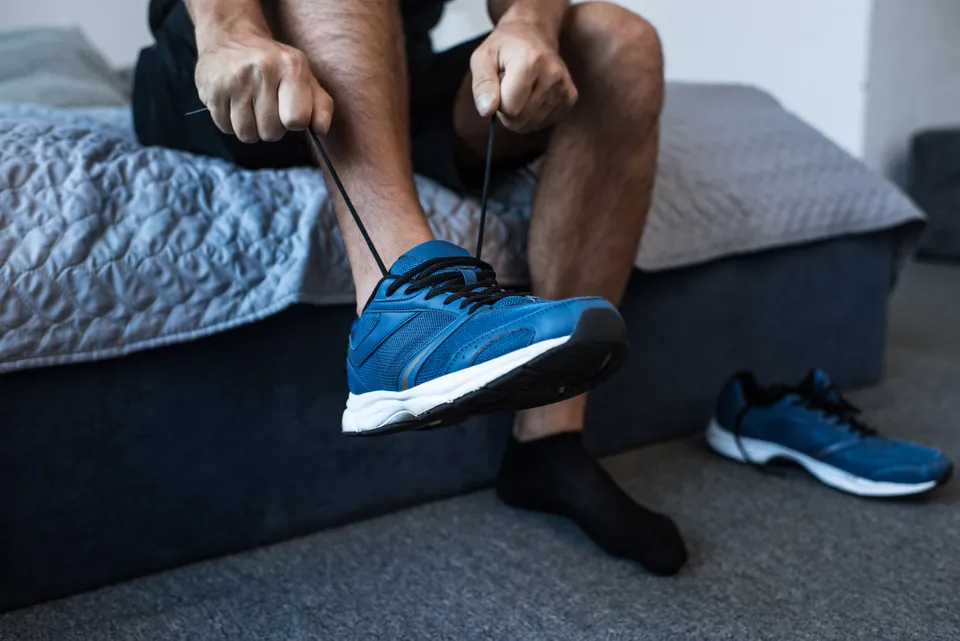 Mann schnürt blauen Sneaker