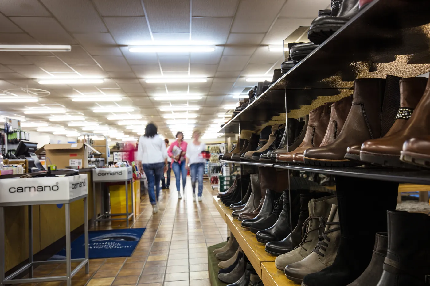 Kundinnen stöbern im Gang zwischen den Schuhregalen